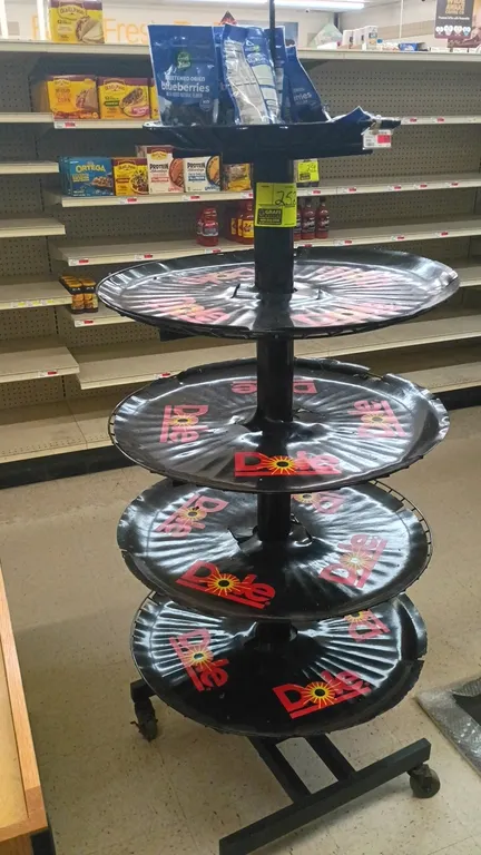 Dole 5-tier portable round merchandise display rack. Features (5) round branded display tiers. 27" round x 73"H. Mounted on a mobile caster base. Incl