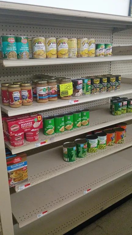 Contents of 4' shelving section. Includes assorted canned and packaged grocery goods featuring gravy, mashed potatoes, green beans, and seasoned cabba