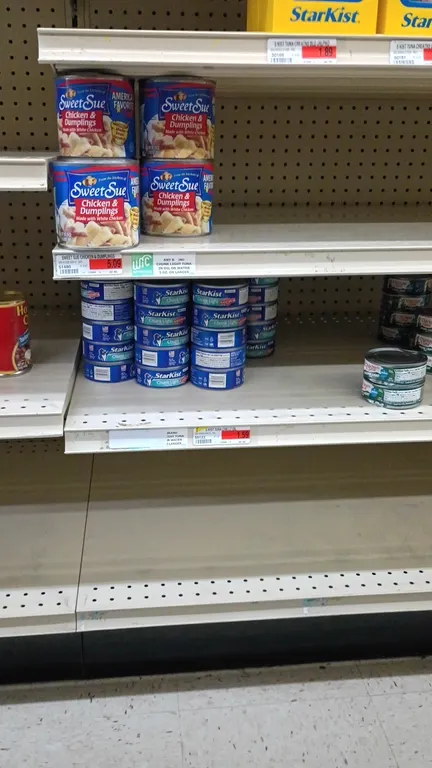 Contents of 4' grocery shelving section. Assorted packaged and canned goods include tuna, sardines, crabmeat, deviled ham spread, corned beef, corned