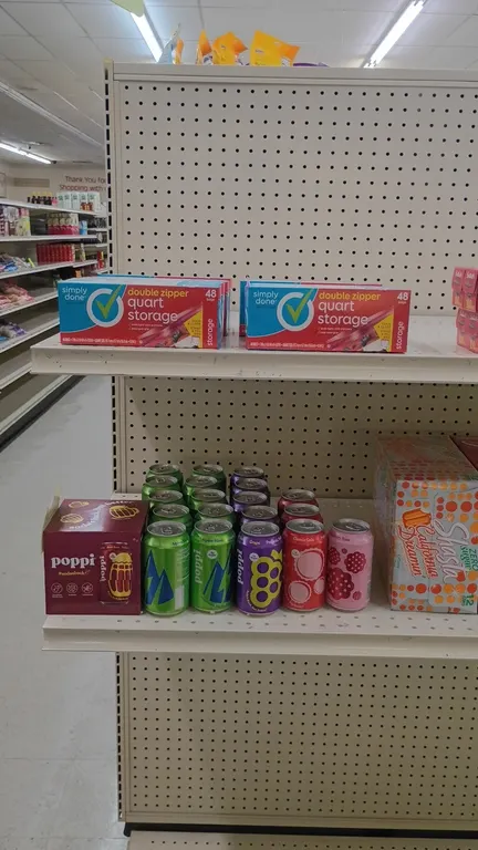 Assorted beverage and household merchandise lot. Includes Poppi soda, Shasta soda 12-packs, a 24-pack of Diet Mountain Dew, Saran Premium plastic wrap