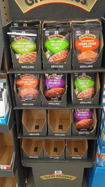 McCormick Grill Mates retail floor display stand. Features multi-tier cardboard construction with organized product trays. Includes remaining McCormic