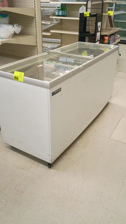 Master-Bilt self-contained commercial chest freezer. Features sliding glass top lids, white wire hanging basket, and white exterior finish. 70"L x 26"