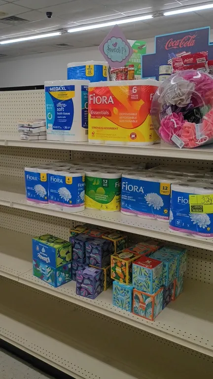 Contents of 4' shelving section. Includes assorted facial tissues, toilet paper, paper towels, and mesh bath sponges. Brands include Kleenex, Fiora, S