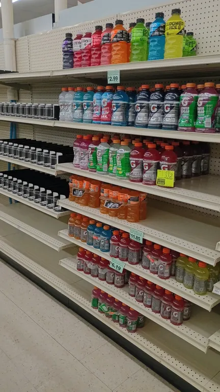 Contents of 4' shelving section of assorted Gatorade and Powerade sports drinks. Features a variety of flavors and formulations in individual bottles