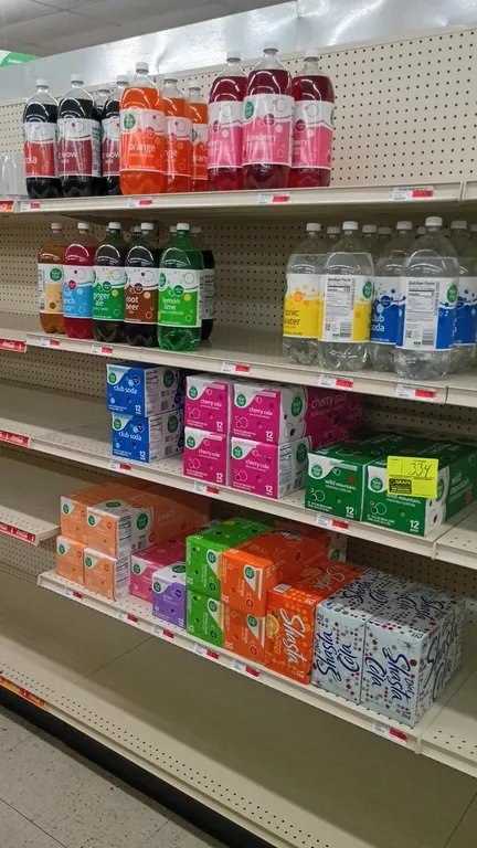 Contents of 4' shelving section. Includes assorted sodas, club soda, and tonic water in 2-liter bottles and 12-pack canned cases. Brands include Food