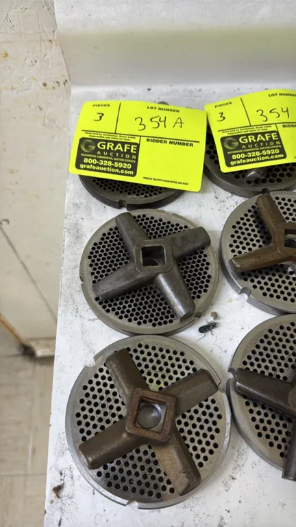 Meat grinder plates and cutting blades. Features 4" diameter perforated grinder plates and 4-wing cutting knives.