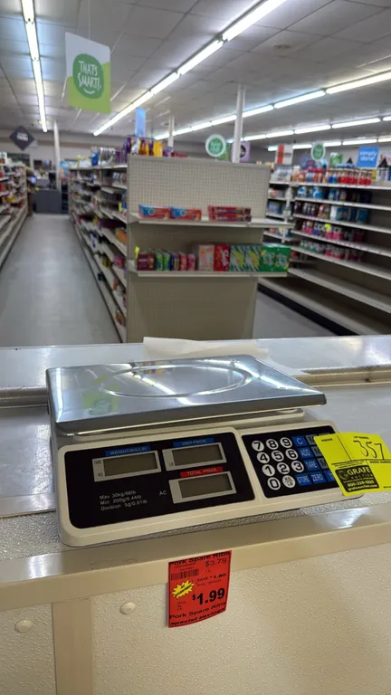 Digital price computing scale. Features stainless steel weighing platform, digital displays for weight, unit price, and total price, and numeric membr