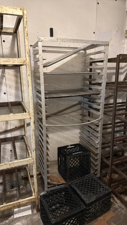 Aluminum side-load pan rack. Features multi-tier channel slides and aluminum frame construction. Contents and surrounding items not included.