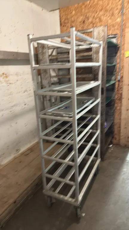 Aluminum meat platter rack. Features welded aluminum tubular frame construction and multi-tier platter runners. Mounted on swivel casters.