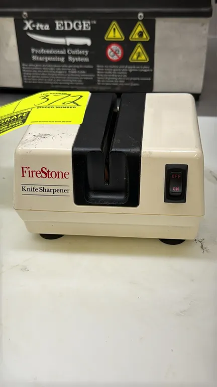 McGowan FireStone 1902W electric knife sharpener. Features a central sharpening slot, front-mounted on/off rocker switch, and rubber suction feet. Ele