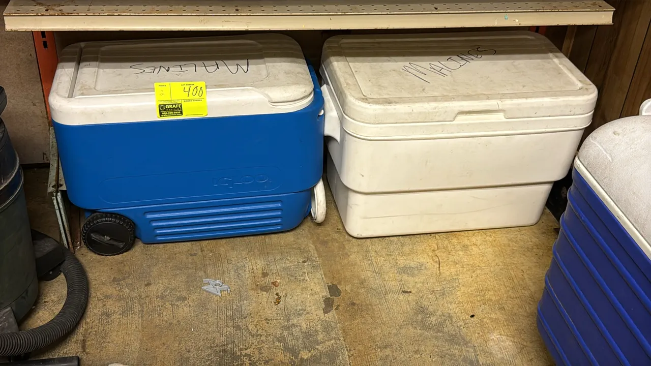 Assorted ice chest coolers. Includes (1) Igloo blue and white wheeled cooler with integrated wheels and (1) white rectangular ice chest cooler with si
