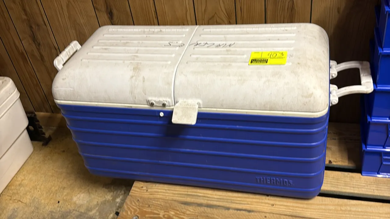 Thermos plastic insulated chest cooler. Features dual side carry handles, front latch closure, and a hinged lid with support strap. 34"L.