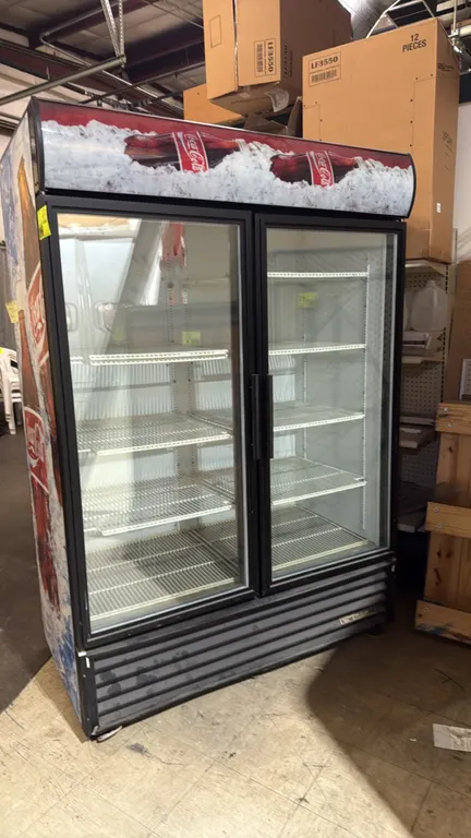 True GDM-49 self-contained 2-door glass door beverage merchandiser cooler. Features double-pane glass doors, adjustable wire shelving, illuminated Coc