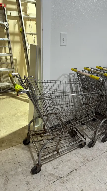 Metal wire shopping carts. Features nesting design, wire basket construction, lower storage trays, yellow handle grips, and swivel casters. Note: Unit