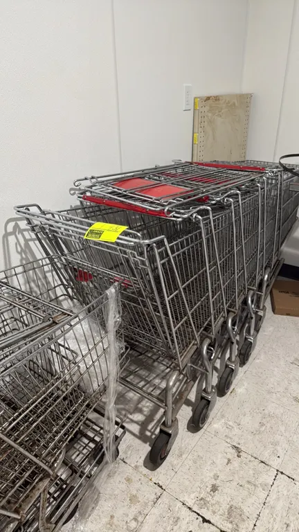 Metal wire shopping carts. Features nesting design, wire basket construction, folding child seat with red plastic flap, and lower tray rack. Mounted o