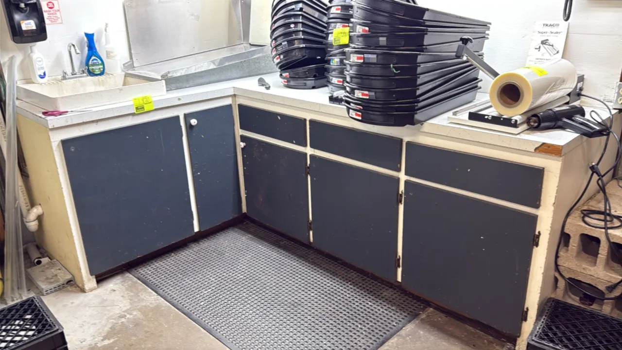 L-shaped laminate cabinet and countertop. Features drop-in utility sink with faucet, lower cabinet doors, and drawers. 72" x 40". Contents and counter