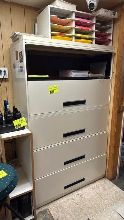 Metal 5-drawer lateral file cabinet. Features recessed handle pulls and beige finish with a top flipper door/rollout shelf. 42"W. Contents not include