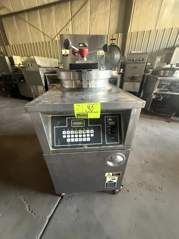 2010 BKI LGF-FC commercial pressure fryer. Features digital touchpad controls, round fry pot with internal basket, and built-in filtration drawer. Gas