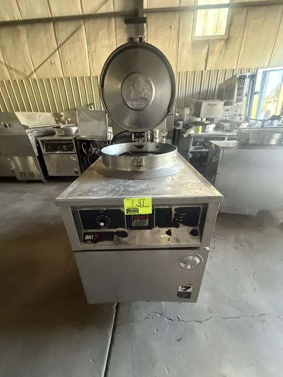2002 BKI FKM-F commercial electric pressure fryer. Features stainless steel construction, hinged pressure locking lid, round fry pot with wire basket,