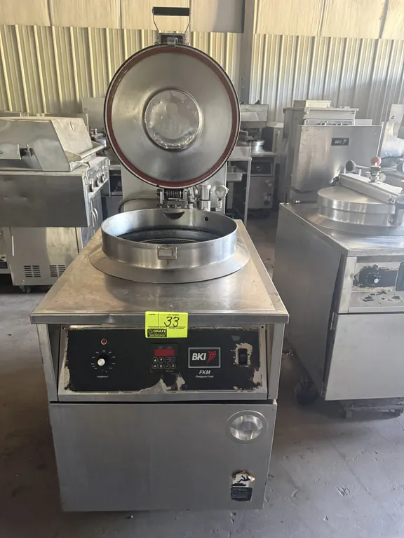 2007 BKI FKM-F commercial electric pressure fryer. Features stainless steel construction, hinged locking lid, front control panel, and internal circul
