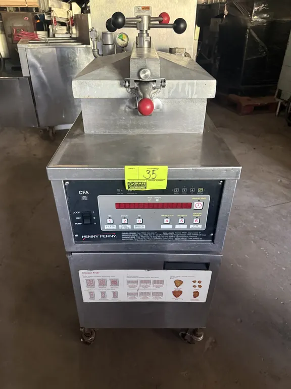 Henny Penny PFE500.2 electric pressure fryer. Features digital programmable controls, locking lid mechanism, built-in filtration system, and wire fry