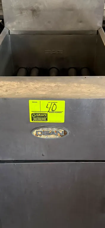 Dean gas deep fryer. Features stainless steel construction, single vat with burner tubes, rear splash guard, and lower cabinet door. Gas-powered. Moun