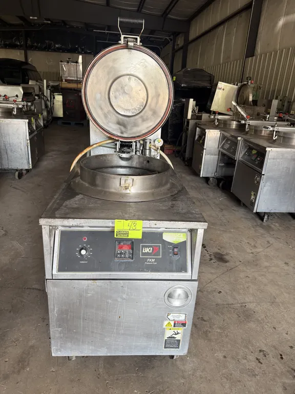 2011 BKI FKM-F commercial pressure fryer. Stainless steel construction. Features digital controls, analog thermostat dial, pressure lid assembly with