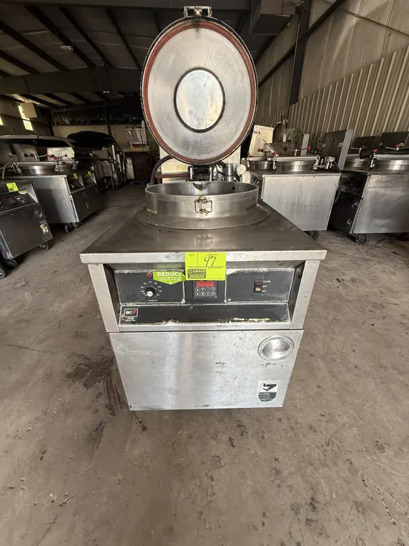 BKI FKM commercial pressure fryer. Features stainless steel construction, round fry pot with wire basket, locking lid mechanism, digital control panel