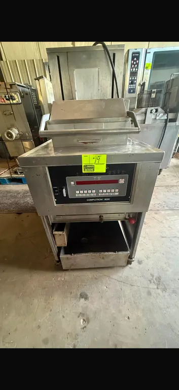 Henny Penny commercial fryer with Computron 8000 digital controls. Features stainless steel construction, multi-tier wire fry basket assembly, and low