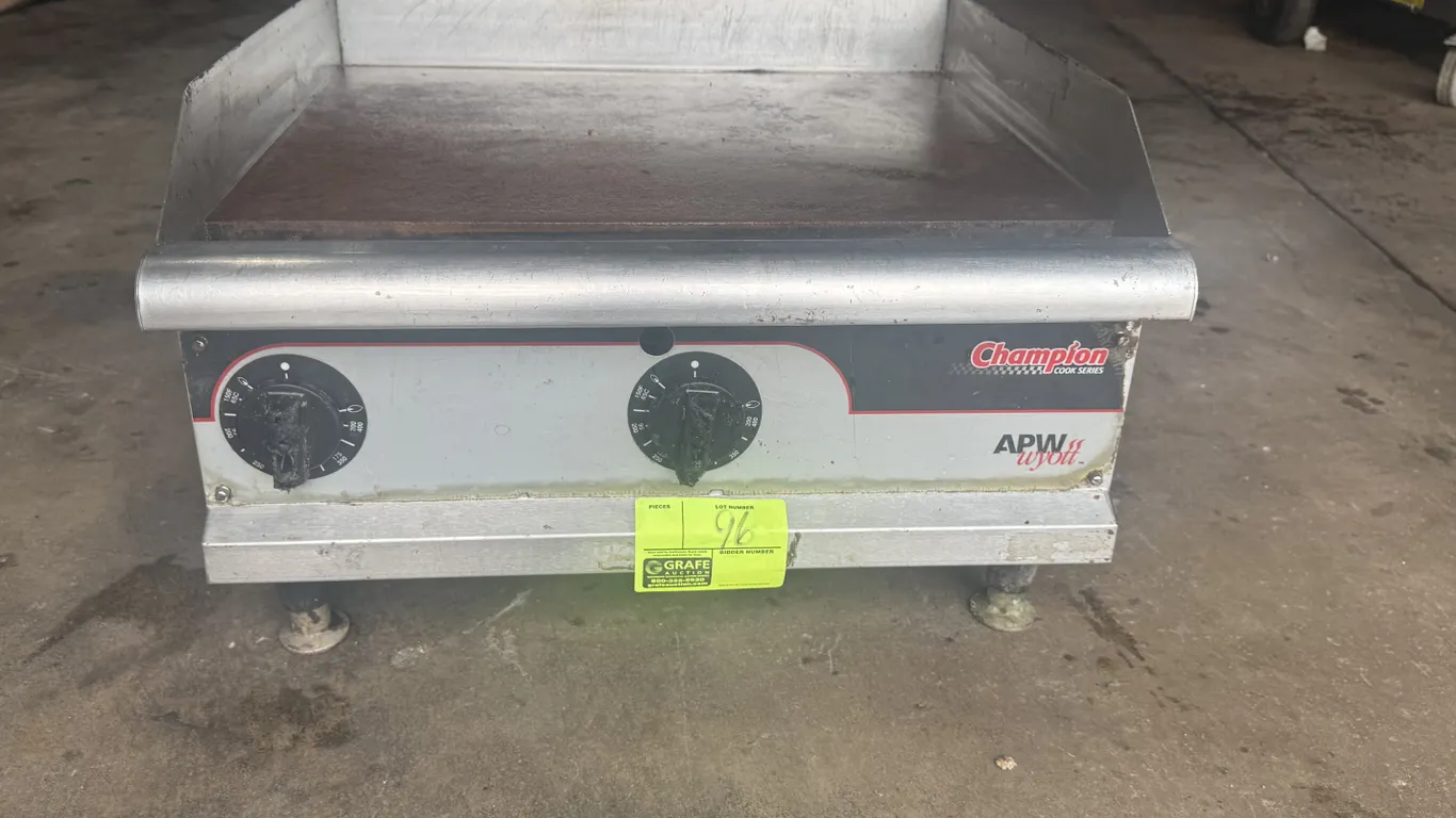 APW Wyott Champion Cook Series 24" countertop gas griddle. Features stainless steel construction, 2 control dials, side and rear splash guards, front