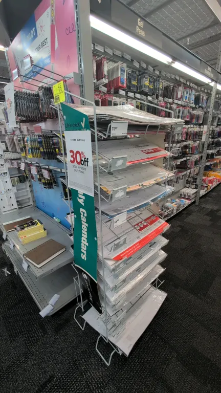 Metal merchandise display rack. Features multi-tier wire shelving designed for flat merchandise display with integrated label holders. 23"W x 61"H. Co