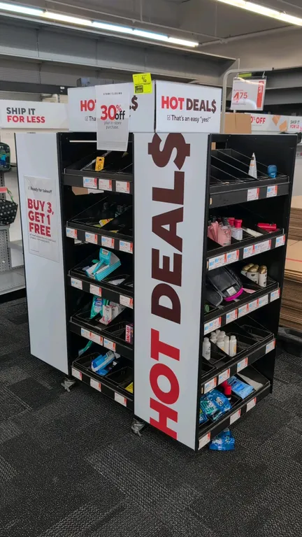 Metal and poly portable merchandise display rack. Features multi-tier angled display shelves with dividers and graphic signage panels. 51" x 64"H. Mou