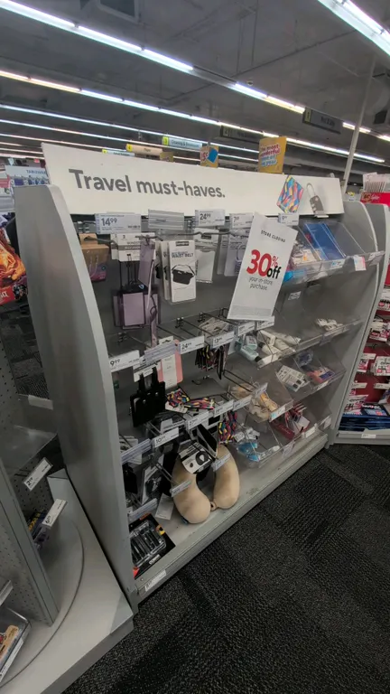 Double-sided laminate merchandise display rack. Features multi-tier angled shelving, clear bin dividers, peg hooks, curved side panels, and top signag