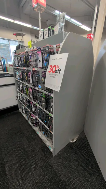 Double-sided laminate merchandise display rack. Features gray finish, hanging peg hooks, and wire display shelves. 51"L. Contents not included.