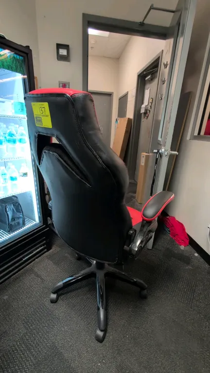 2021 Emerge Vortex gaming chair. Features black and red faux leather upholstery, padded flip-up armrests, pneumatic height adjustment, and tilt tensio