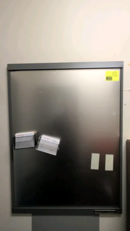 Magnetic bulletin board. Features metallic surface with gray metal frame and wall-mounted design. 4' x 3'. Contents not included.