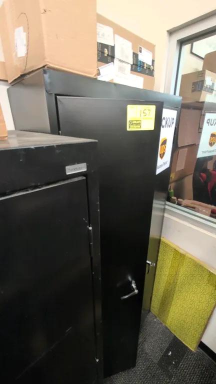 Metal 2-door storage cabinet. Features a black finish and locking handle with key. 30"W x 72"H. Contents and boxes not included.