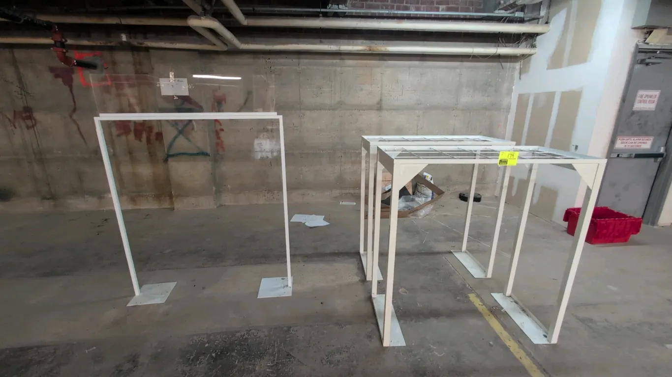 Metal merchandise display racks. Features white painted metal frame construction, top wire grid platform, and flat base plates. Dimensions: 48" x 48"H