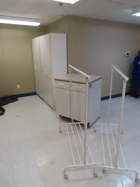 Lot - (2) 2 Door Cupboards, Small 2 Door Cupboard, 2 Portable Garment Racks *Located at 4831 93 Ave, Edm.