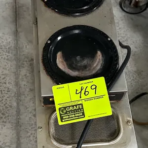 Bunn commercial coffee brewer. Features stainless steel construction, two upper warmers, lower warmer, and top water reservoir screen. Mounted on a co