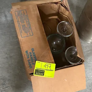 Box of assorted glassware. Features clear stemmed glassware in a cardboard storage box.