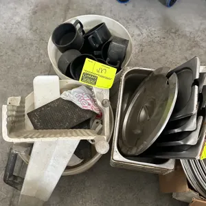 Assorted restaurant smallwares. Includes stainless steel insert pans, lids, black mugs, plastic containers, slicer food chute parts, and related acces