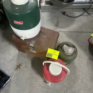 Assorted beverage coolers and metal toolbox. Includes vintage and portable water jugs featuring carrying handles and dispensing spigots, accompanied b