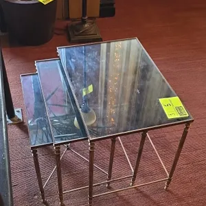 Glass-top metal frame nesting tables. Features glass inset tops, bronze-tone metal frames, fluted legs, and side stretchers. 22" x 18"H.