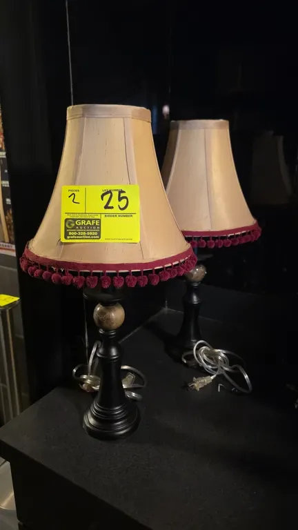 Vintage metal table lamps. Features dark-finish turned metal bases with spherical center accents and beige fabric bell shades with burgundy tassel tri