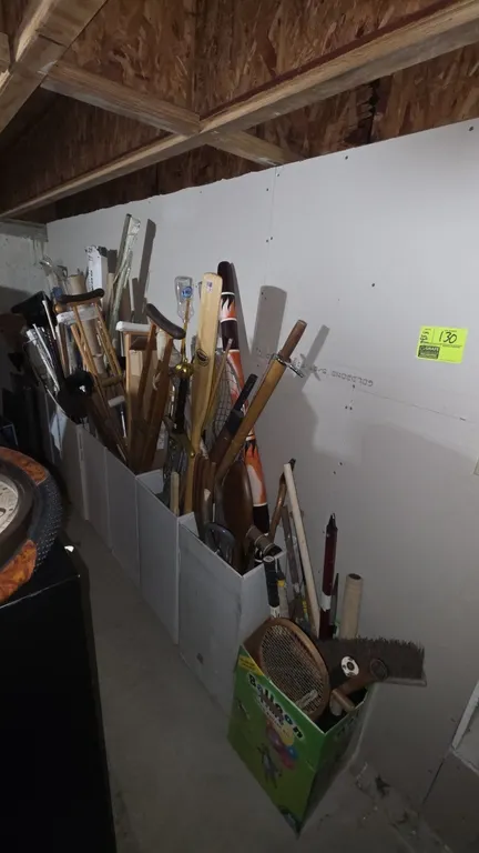 Assorted household, cleaning, and sporting goods lot. Includes wooden and medical crutches, assorted curtain rods with decorative finials, brooms, mop
