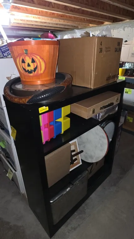 Metal 4-tier shelf with assorted contents. Includes poly organizers, stretched art canvases with tabletop easels, hand drums, metal bin with hinged li