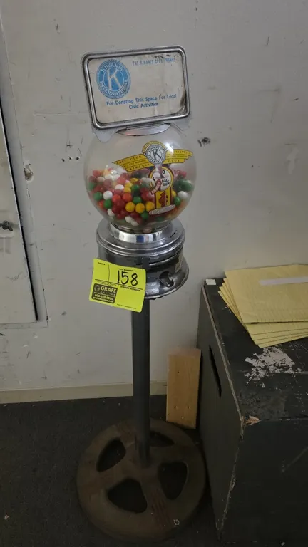 Vintage Ford 1¢ gumball machine with Kiwanis Club topper. Features glass globe with Ford Ball Gum and Kiwanis decals, chrome coin mechanism, and top K