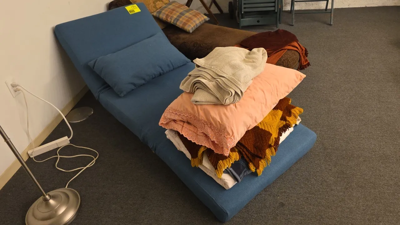 Upholstered adjustable lounge. Features blue fabric upholstery, reclining backrest, and matching lumbar pillow. 6'L. Exclusion Note: Blankets, pillows