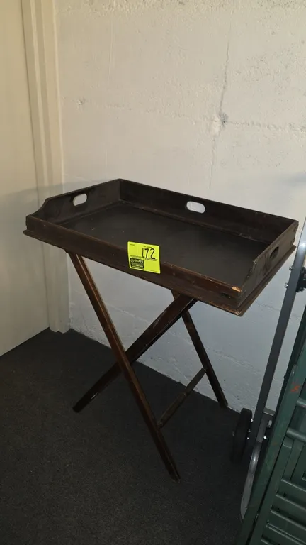 Wood butler tray table. Features removable wood tray with cutout carry handles. 30" x 20". Mounted on folding wooden X-frame base with fabric webbing